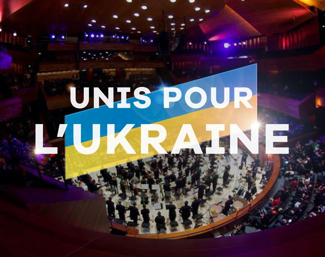Drapeau de l'Ukraine sur lequel est écrit "Unis pour l'Ukraine", avec en fond l'auditorium de Radio France.