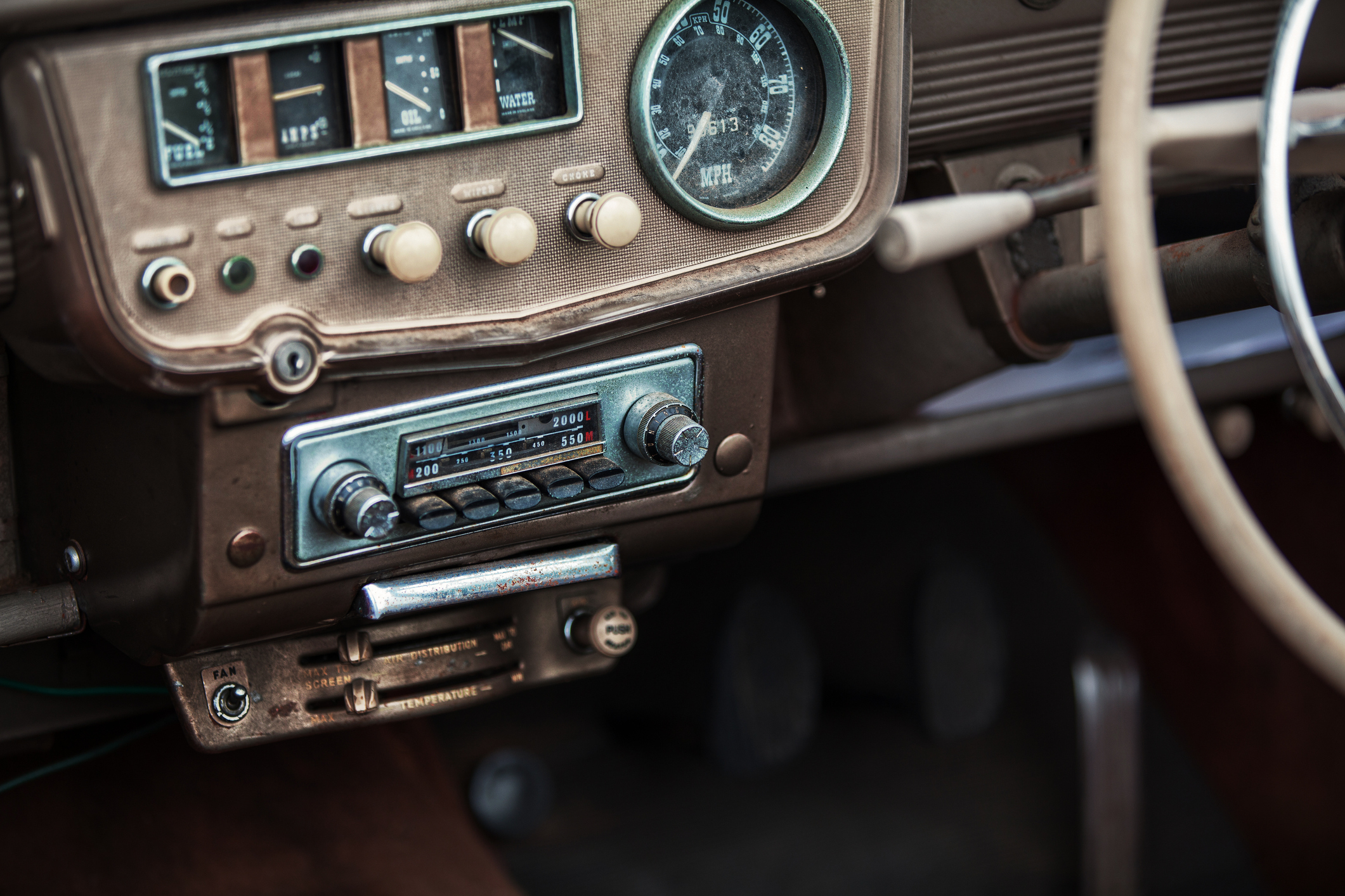 Une radio ancienne intégrée à un tableau de bord de voiture.